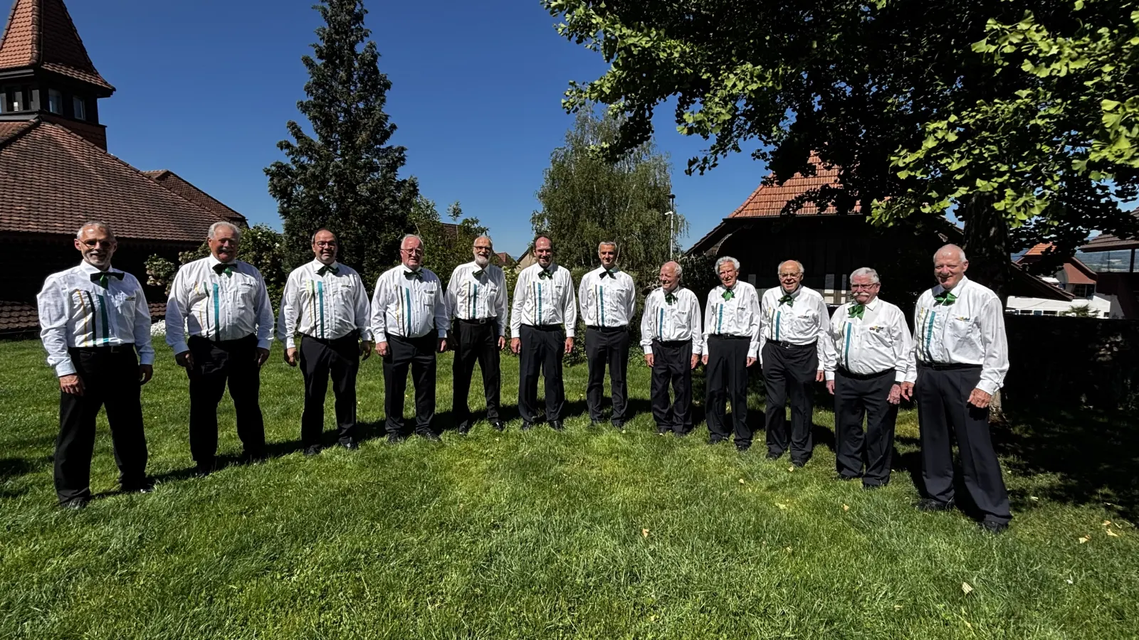 Der Chor in Vereinskleidung auf der Wiese vor der Kirche