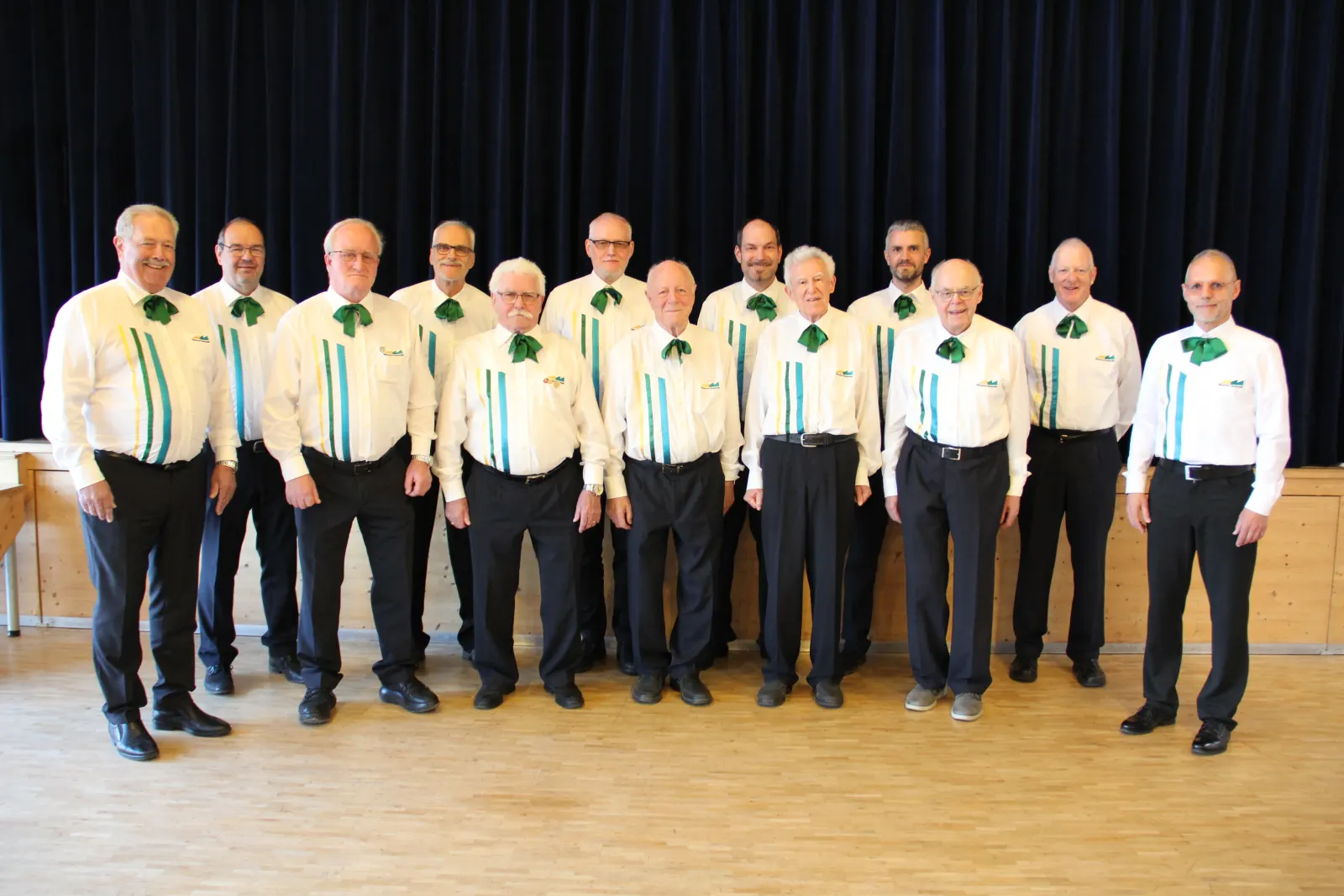 Gruppenfoto des Chors vor dem dunklen Vorhang